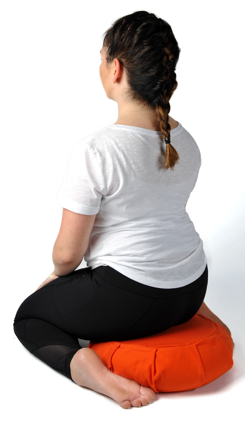 Sitting on meditation cushion